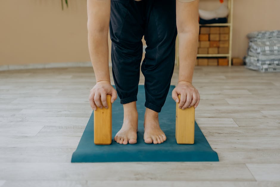 Person doing a gentle seated forward bend on a yoga mat with attention